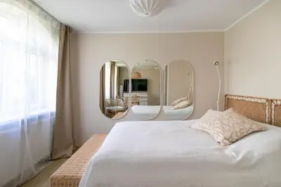 a bedroom with a bed with two sinks and mirrors at Harmony Hill Apartments in Druskininkai
