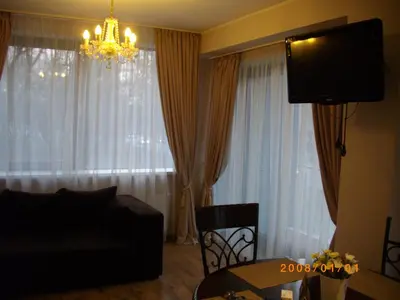 a living room with a couch and a chandelier at Centro apartamentai - Vingio apartamentai in Vilnius