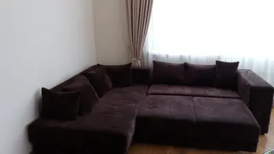 a brown couch in a living room with a window at Centro apartamentai - Vingio apartamentai in Vilnius