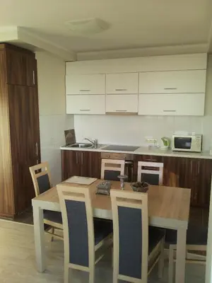 a kitchen with a wooden table and chairs and a kitchen counter at Centro apartamentai - Vingio apartamentai in Vilnius