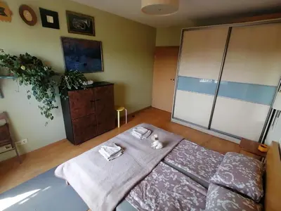 a bedroom with a bed and a dresser with towels on it at Jauki erdvĖ in Vilnius