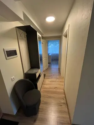 a hallway with a mirror and a chair in a room at Jaukus butas arti Šiaulių miesto in Šiauliai