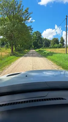 a view of a dirt road from the dashboard of a car at Jaukus butas arti Šiaulių miesto in Šiauliai