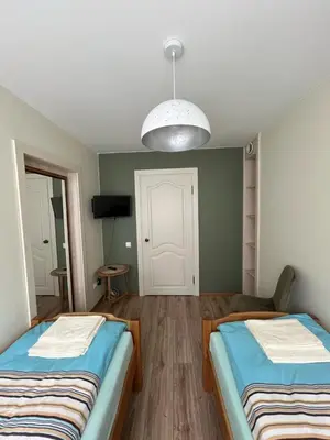 a room with two beds and a pendant light at Jaukus butas arti Šiaulių miesto in Šiauliai