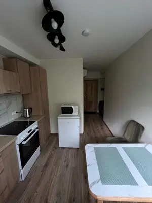a small kitchen with a table and a microwave at Jaukus butas arti Šiaulių miesto in Šiauliai