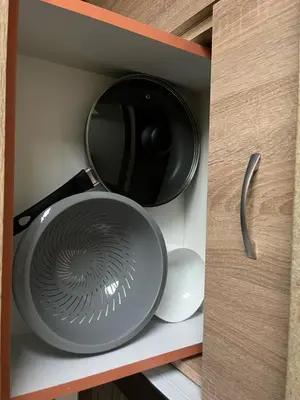 a frying pan and a bowl in a drawer at Jaukus butas arti Šiaulių miesto in Šiauliai