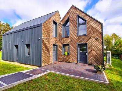 a modern house with a gray and wooden facade at Sofijos Slėnis in Pakniškiai