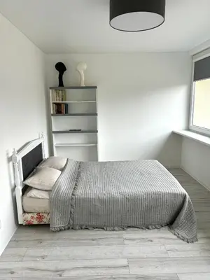 a bedroom with a bed in a white room at Vivist apartments in Druskininkai