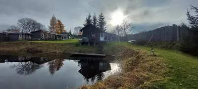 a house on the side of a river with a person at Merkioaidas in Sližiūnai