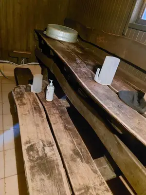 two wooden tables in a room with toilets at Merkioaidas in Sližiūnai