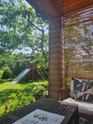 a patio with a table and a playground in the background at Namelis Birštono mieste in Birštonas
