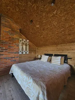 a bedroom with a bed in a brick wall at Namelis Birštono mieste in Birštonas