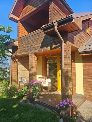 a house with a patio with chairs and flowers at Namelis Birštono mieste in Birštonas