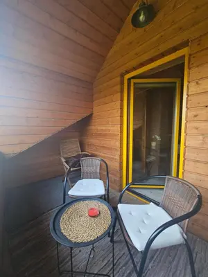 two chairs and a table on the porch of a cabin at Namelis Birštono mieste in Birštonas