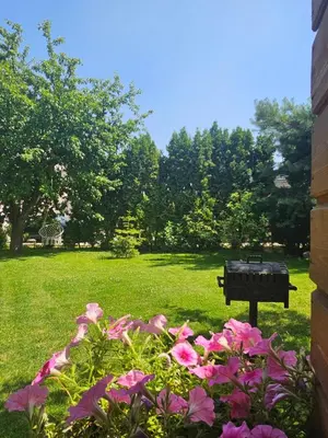 a park with a bench and flowers in the grass at Namelis Birštono mieste in Birštonas