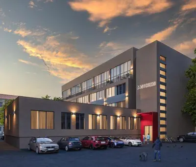a building with cars parked in a parking lot at Studio on Laisves Aleja, Central Kaunas - Self Check In in Kaunas