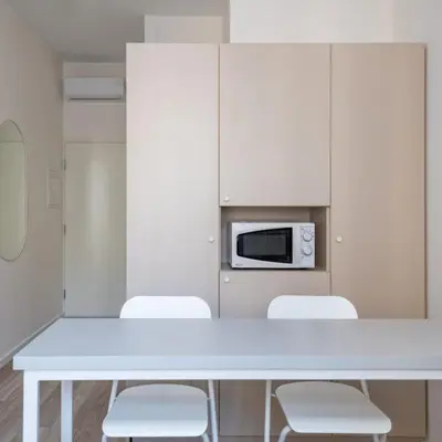 a white table with white chairs and a microwave at Studio on Laisves Aleja, Central Kaunas - Self Check In in Kaunas