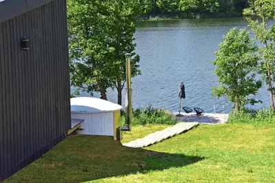 a gazebo next to a body of water at Pineplace trio BANGA in Žaugėdai