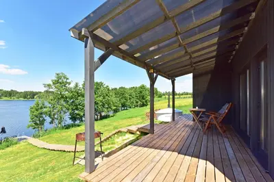 a wooden deck with a view of a lake at Pineplace trio BANGA in Žaugėdai