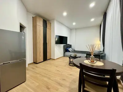 a kitchen and living room with a table and a refrigerator at UAB DU PROCENTAI nt in Šiauliai