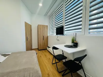 a bedroom with a bed and a desk with two chairs at UAB DU PROCENTAI nt in Šiauliai