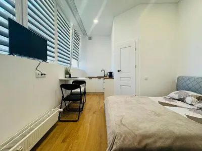 a bedroom with a bed and a desk with a chair at UAB DU PROCENTAI nt in Šiauliai