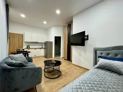 a living room with a bed and a kitchen at UAB DU PROCENTAI nt in Šiauliai
