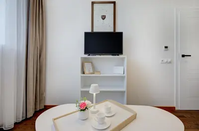 a living room with a table and a tv at Modern Apartment near Old Town & River in City Center in Vilnius
