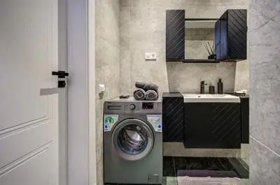 a bathroom with a washing machine and a sink at Modern Apartment near Old Town & River in City Center in Vilnius