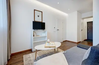 a living room with a couch and a table at Modern Apartment near Old Town & River in City Center in Vilnius