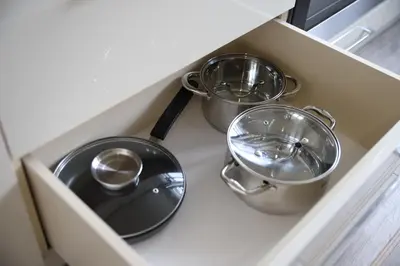 three pots and pans in a drawer in a kitchen at Butterfly apartment in Šiauliai