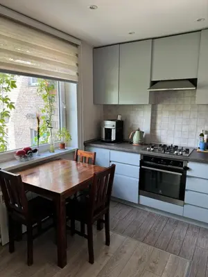 a kitchen with a wooden table and a kitchen with white cabinets at Algirdo Apartments, Self Check-in, Free Private Parking in Vilnius
