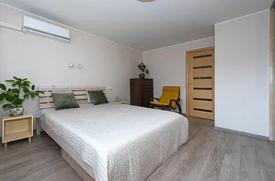 a bedroom with a white bed and a yellow chair at Algirdo Apartments, Self Check-in, Free Private Parking in Vilnius