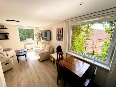 a living room with a table and a large window at Algirdo Apartments, Self Check-in, Free Private Parking in Vilnius