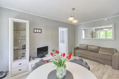 a living room with a table and a couch at Apartamentai Vilniaus alėjoje in Druskininkai