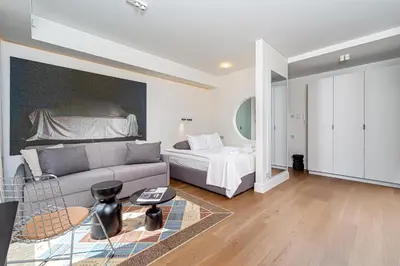 a living room with a couch and a bed at cohost I New Apt w-Balcony I Air Condition I Free Parking & Netflix I By Botanical Park in Kaunas