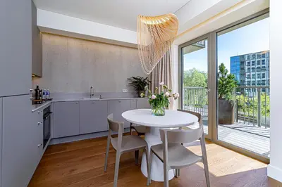 a kitchen with a white table with chairs and a window at cohost I New Apt w-Balcony I Air Condition I Free Parking & Netflix I By Botanical Park in Kaunas