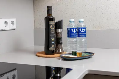 a bottle of wine and two bottles of water on a counter at cohost I New Apt w-Balcony I Air Condition I Free Parking & Netflix I By Botanical Park in Kaunas