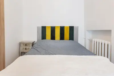 a bedroom with a white bed with a colorful headboard at Kestutis Luxury Apartment in Šiauliai