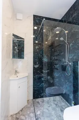 a bathroom with a glass shower and a sink at Kestutis Luxury Apartment in Šiauliai