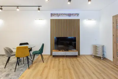 a living room with a table and a flat screen tv at Kestutis Luxury Apartment in Šiauliai