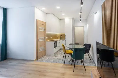 a kitchen with a glass table and chairs at Kestutis Luxury Apartment in Šiauliai