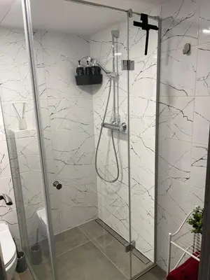 a shower with a glass door in a bathroom at Mini loft in Kaunas