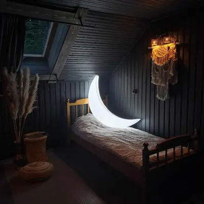 a bedroom with a bed with a moon light on it at Sodyba Mėnulio Slėnis in Padubysys