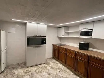 a kitchen with white appliances and wooden cabinets at Sodyba Mėnulio Slėnis in Padubysys