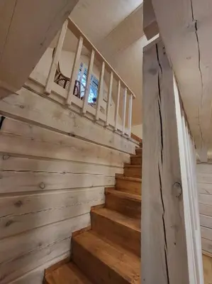 a staircase in a house with wooden walls at Ramus poilsis miške su kedro pirtimi ir kubilu in Marcinkonys