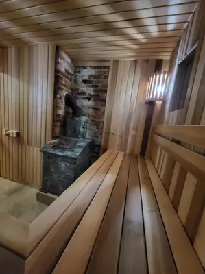 a room with a wooden bench in a sauna at Ramus poilsis miške su kedro pirtimi ir kubilu in Marcinkonys