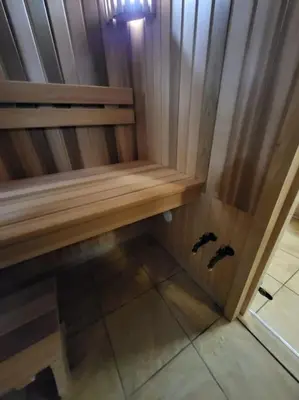 a wooden bench with two pigeons sitting on the floor at Ramus poilsis miške su kedro pirtimi ir kubilu in Marcinkonys