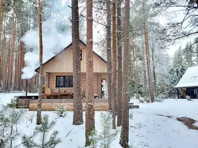 a log cabin in the woods in the snow at Ramus poilsis miške su kedro pirtimi ir kubilu in Marcinkonys