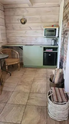 a kitchen with a stove and a microwave at Ramus poilsis miške su kedro pirtimi ir kubilu in Marcinkonys